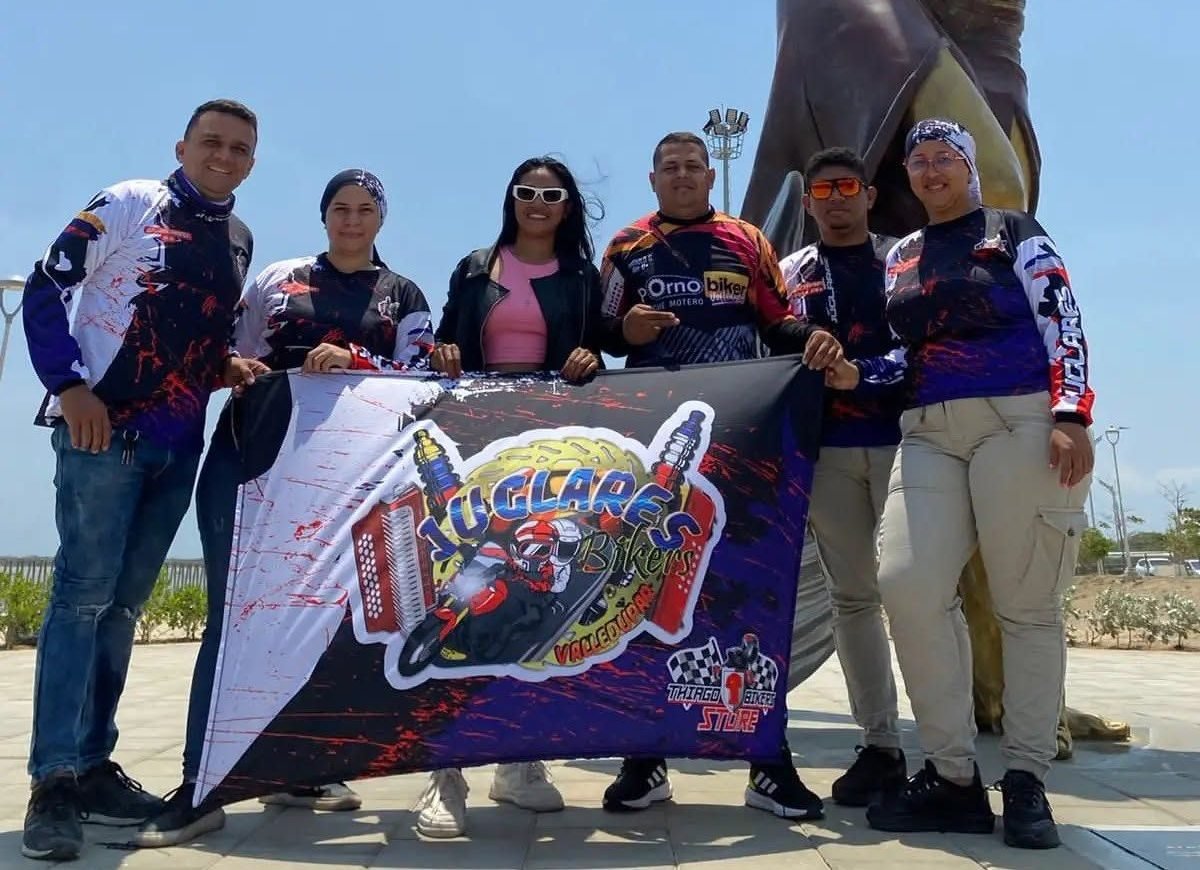 Club de moteros posando con su bandera y sus camisetas