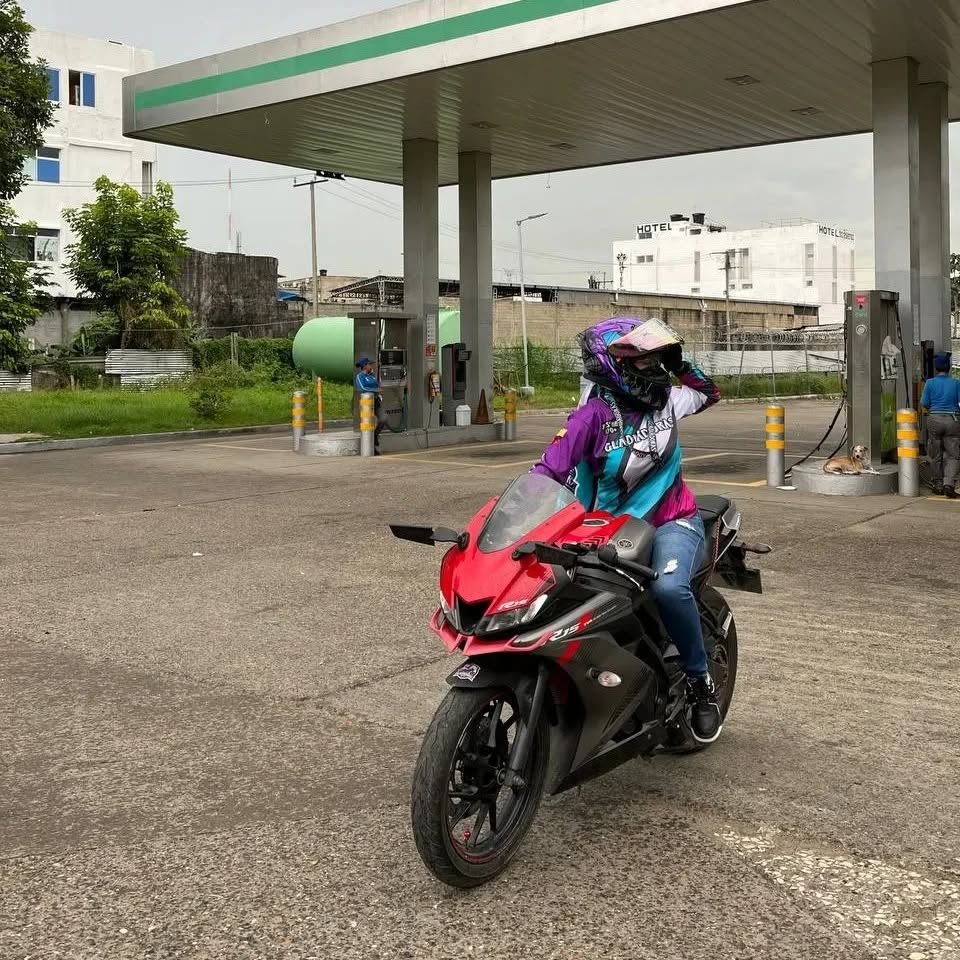 Motociclista con su camiseta de club junto a una moto roja